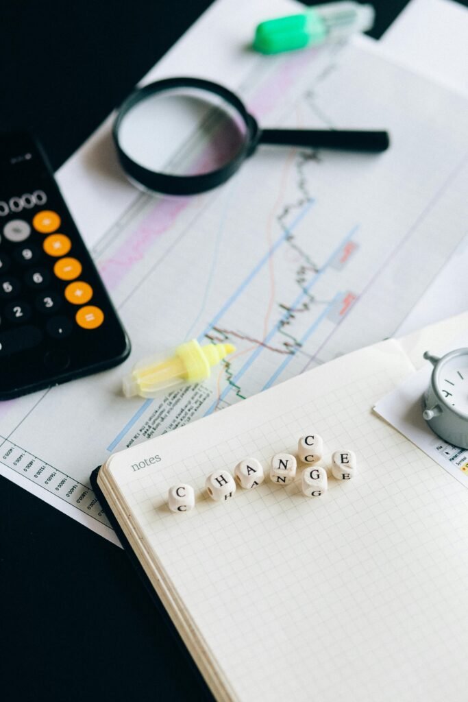 Close-up of financial tools and letter blocks spelling 'CHANGE'.